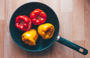 Dört taze kapsiyum ya da baharatlı kıyma ile doldurulmuş dolgulu dolma biber kızartma tavasında pişirmeye hazır.
