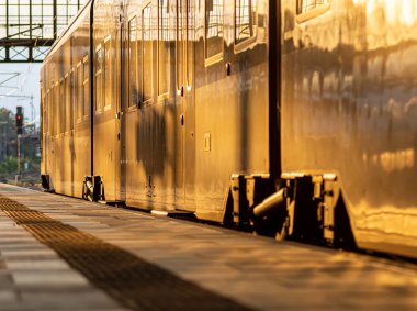 Yolcu treni kapalı bir istasyon terminalinde aydınlatılmış vagon ve pencerelerle bir nakliye ve seyahat kavramına yakın mesafede.