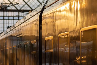 Yolcu treni kapalı bir istasyon terminalinde aydınlatılmış vagon ve pencerelerle bir nakliye ve seyahat kavramına yakın mesafede.