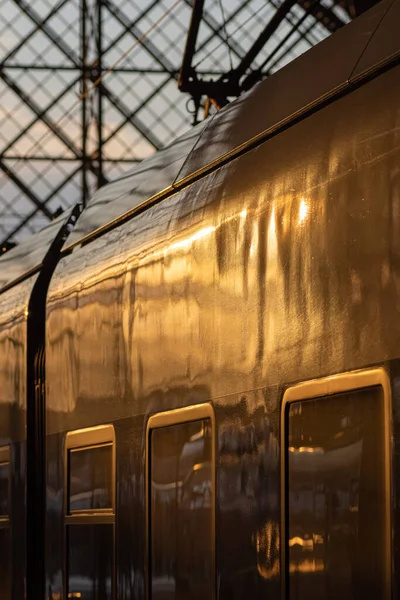 Yolcu treni kapalı bir istasyon terminalinde aydınlatılmış vagon ve pencerelerle bir nakliye ve seyahat kavramına yakın mesafede.