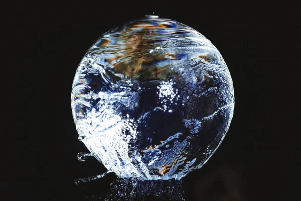 Una Bola Vidrio Sobre Que Fluye Agua Frente Fondo Negro —  Fotos de Stock