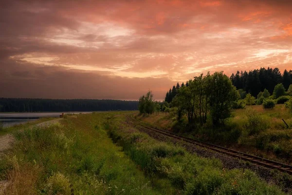 オレンジの夕焼けの中を鉄道が走る風景 — ストック写真