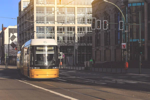 Yellow  public transportation tram passing by the city of Berlin Germany