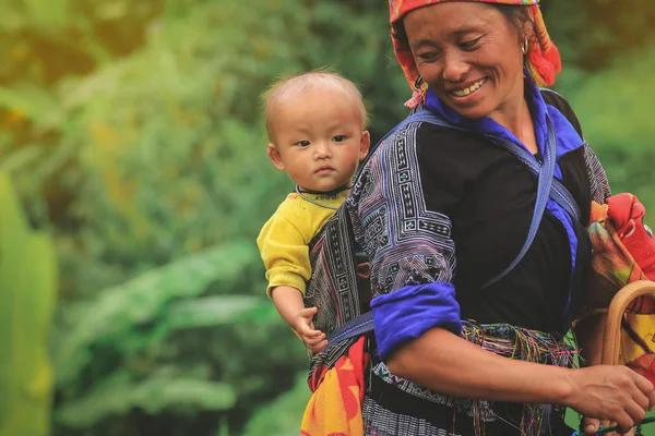 Mu cang chai, Vietnam-Ağustos 27, 2018: Smling Hmong kabile kadın çocuğunu Mu cang chai Kuzey Vietnam çantasında taşıma