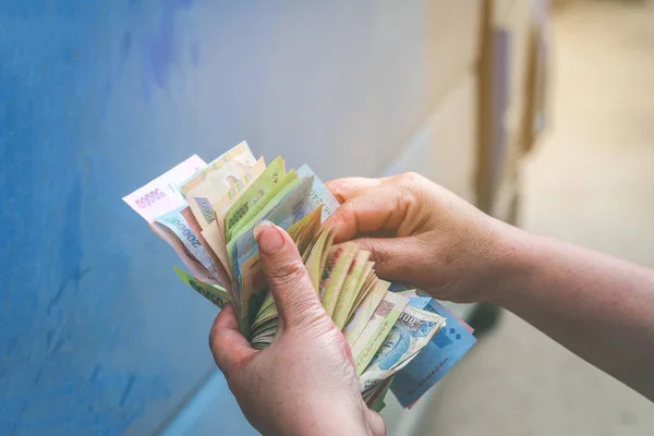 Vietnamlı kadınların elindeki dong banknotuna odaklan.