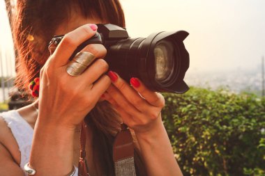 Tatilsırasında slr fotoğraf makinesi profesyonel fotoğrafçılık ile fotoğraf çekmek fotoğrafçı asyalı kadın yumuşak odak.