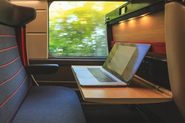 Comfortable seat in first class with laptop on train compartment