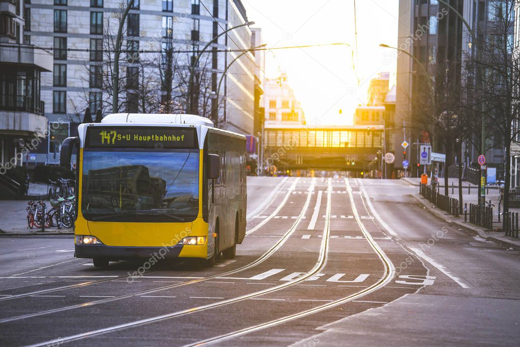 Yellow public transportation bus passing by the city of Berlin Germany