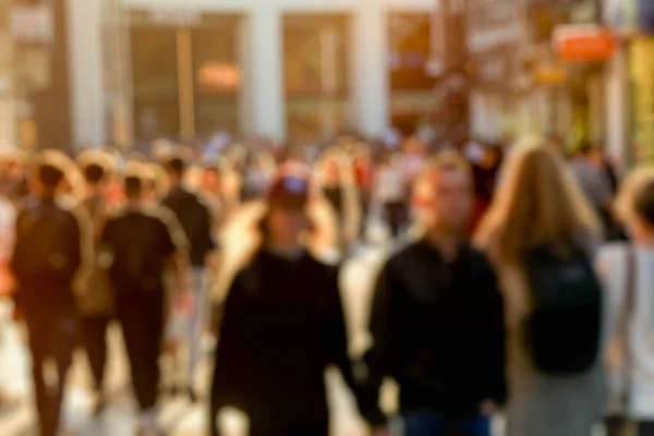 Bulanık arka plan insanları şehir merkezinde yürüyor.