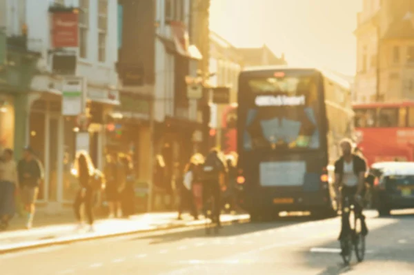 Blurred image of people walking and buses on Oxford street. England