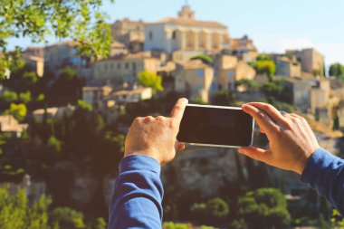 Elde cep telefonu Fransa 'nın en güzel köylerinden biri olan Gordes köyünün fotoğrafını çekiyor.