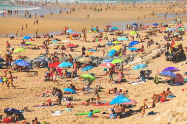 Yaz tatilinde plajda dinlenen insanlarla dolu kalabalık bir plaj.