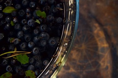 Bir vazo suda yüzen taze yaban mersini.