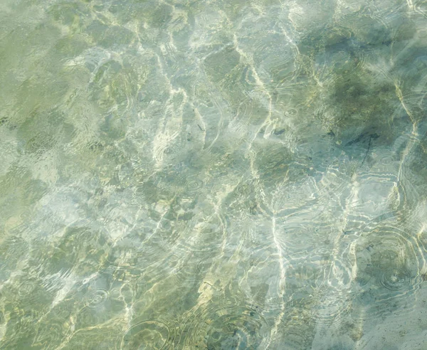 Çeşmedeki su, güneşli bir günde çekilmiş fotoğraf. Suyun dibindeki fıskiyenin güzel parlaklığı.