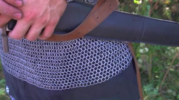 Close-up of a belt worn over chain mail. the video was filmed in sunny weather, so beautiful sun glare are visible on the chain mail — Stock Video