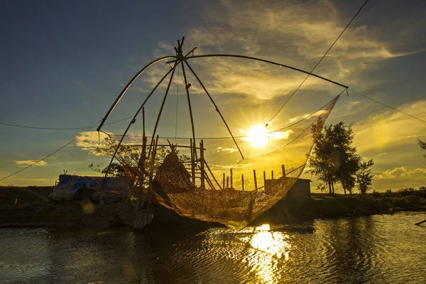 夕暮れ時の川の上に竹のフレームを持つ伝統的な釣りネット — ストック写真