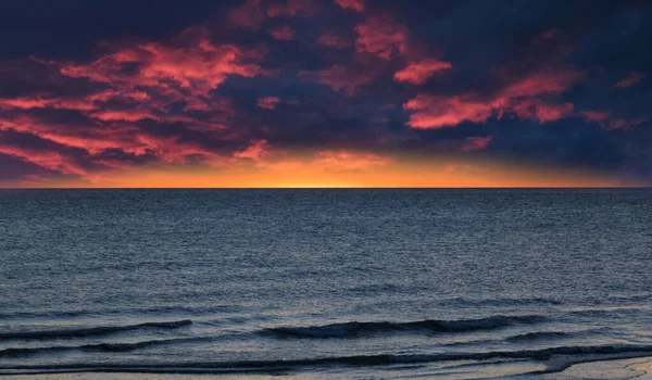 Dramatisk Mörkröd Och Gul Grumlig Himmel Över Blått Hav Med — Stockfoto