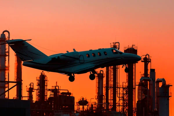 Gece gökyüzüne karşı özel bir jet. Arka plan sanayi bölgesi..