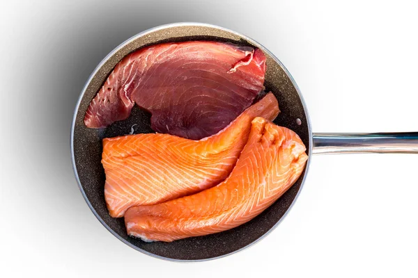Tunfisch und Lachssteak in der Pfanne vor dem Braten.