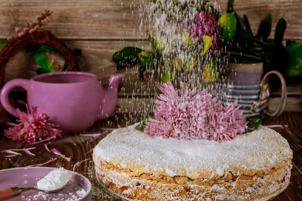 糖粉洒在蛋糕上 上有新鲜的花 桌上有茶壶 — 图库照片