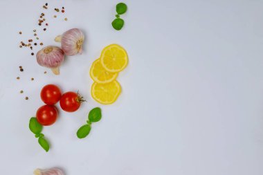 Beyaz arka planda limonlu ve domatesli doğal baharatlar.