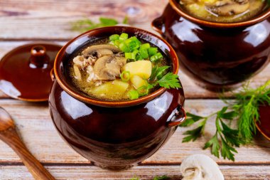 Patatesli mantar ve kapaklı kil kaplarda et...