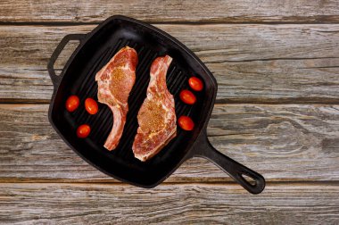 Domatesli ızgara tavada pişmemiş domuz filetosu. Üst görünüm.