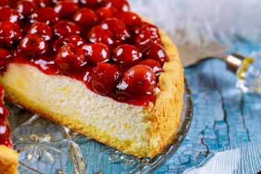Mavi ahşap arka planda kiraz soslu cheesecake. Yakın plan..