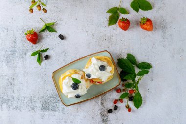 Krem şantili ve yabanmersinli çörekler. Üst görünüm.