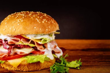 Jambonlu sandviç, marul, peynir ve domates. Kapat..