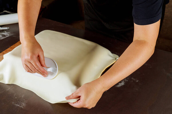 Woman making cake with fondant for party. Technique of baker.