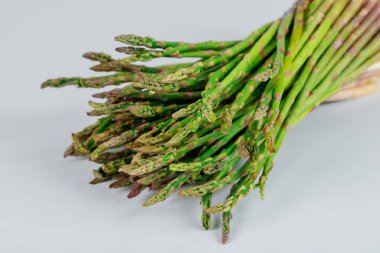 İzole edilmiş beyaz arka planda bir sürü taze yeşil kuşkonmaz. Sağlıklı yemek..