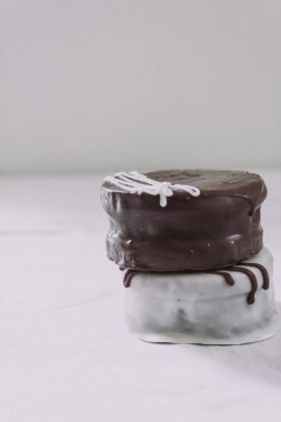 Beyaz arka planda beyaz ve siyah çikolatalı alfajore tatlısı. Arjantin