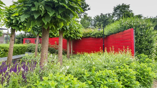 Diseño de jardín con un estanque y una pared roja —  Fotos de Stock