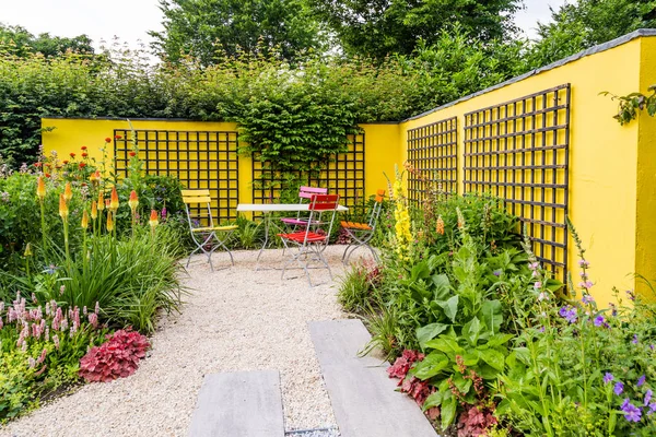 Colorful garden design with yellow wall