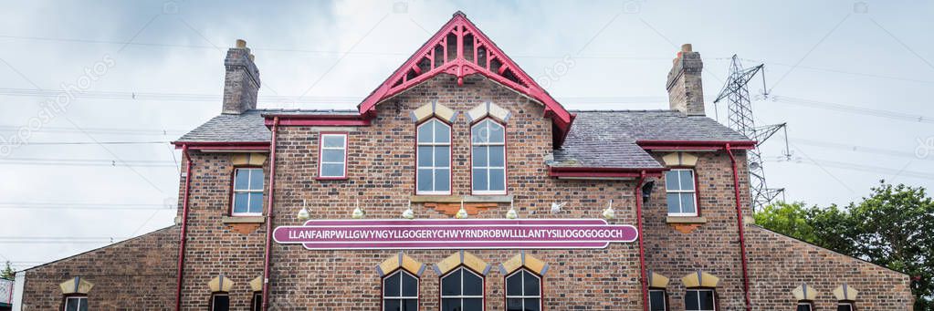 Name sign on the station building of the town with the longest name in Europe on Anglesey island in Wales, UK. The name is abbreviated as Llanfair PG or  Llanfairpwll.