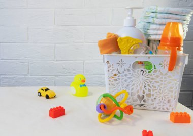 Banyo yapmak ve beslemek için yeni doğan bebekler için aksesuarlar, bir şişe, yüzmek için oyuncaklar, bebek bezi, beyaz bir kutuda sabun.