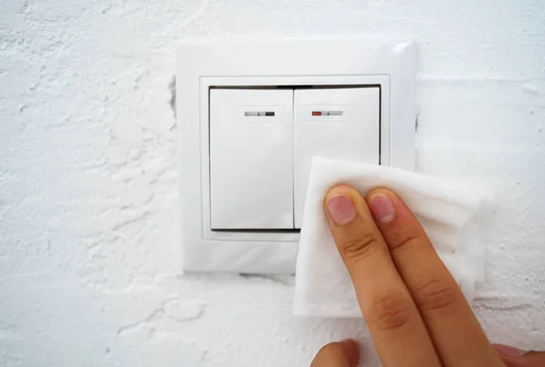 Hygiene Rules Wiping the Light Switch with a Cloth with a Disinfectant Solution