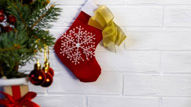 Seçici odak noktası kırmızı ve beyaz Noel çorapları çamaşır ipine asılı beyaz tuğla duvar zeminine karşı. Noel arkaplanı. Noel ağacı ve kırmızı toplar