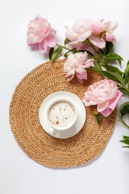 Masada bir fincan kahve ve şakayık çiçekleri var. Üst Manzara. Düz yatıyordu.