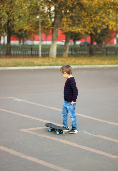 Küçük çocuk paten kaymayı öğreniyor.