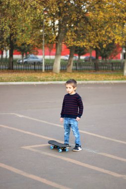 Küçük çocuk paten kaymayı öğreniyor.