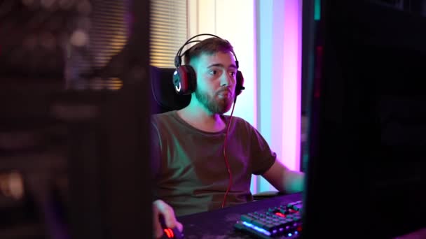 Ein junger Gamer spielt emotional am Computer. — Stockvideo