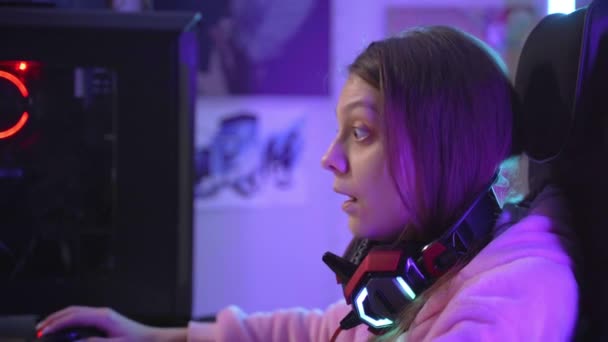 Jong meisje gamer emotioneel reageert op omstandigheden die zich voordoen op de monitor — Stockvideo