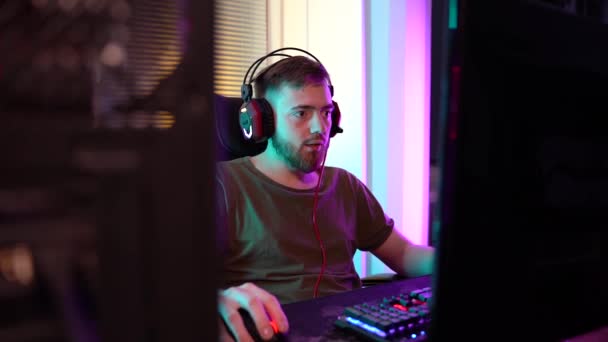 Ein junger Gamer spielt emotional am Computer. — Stockvideo