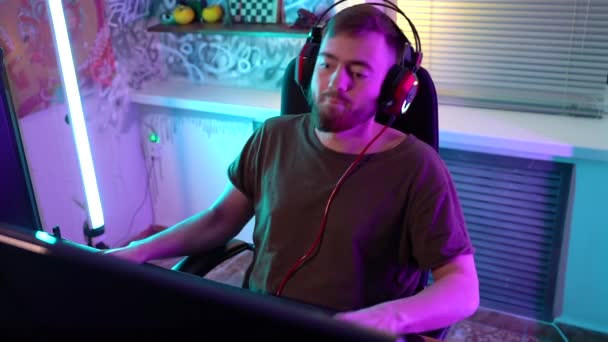 Genç bir oyuncu duygusal olarak bilgisayarla oynuyor.. — Stok video