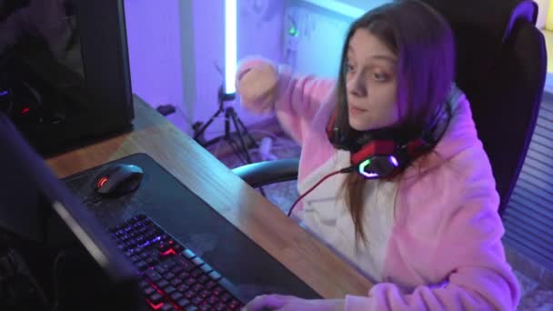 Uma jovem jogadora emocionalmente joga um jogo de computador . — Vídeo de Stock