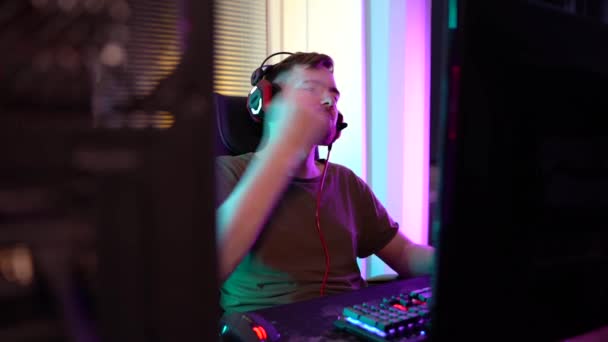 Ein junger Gamer spielt emotional am Computer. — Stockvideo