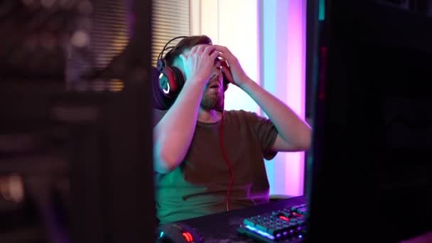 Un jeune joueur joue émotionnellement un ordinateur. — Video