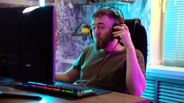 Een jonge gamer speelt emotioneel een computer.. — Stockvideo